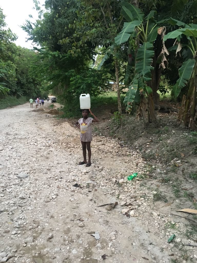 Criança carregando água no Haiti